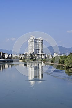 Modern apartment buildings mirrored in a canal, Sanya, China